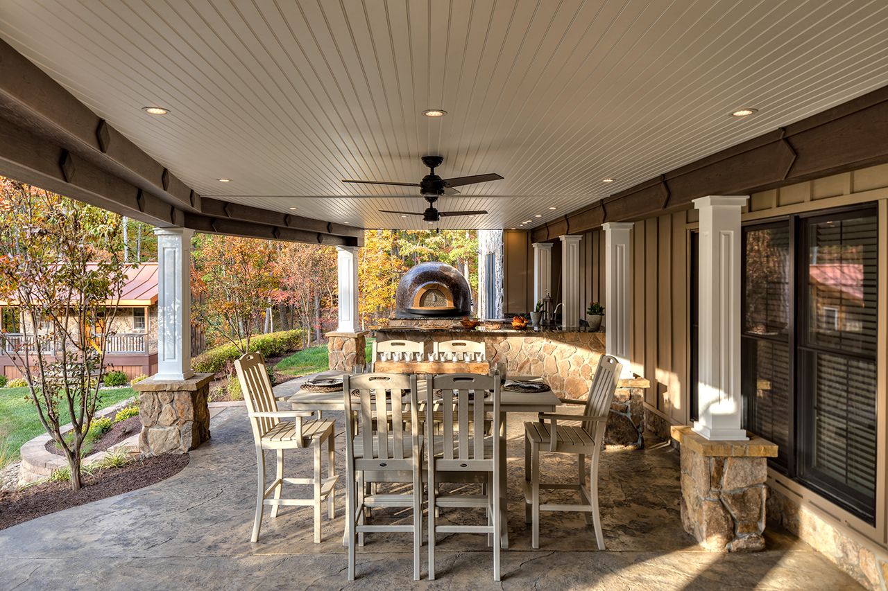Patio under a deck with a nice family dining table and an outdoor kitchen. 