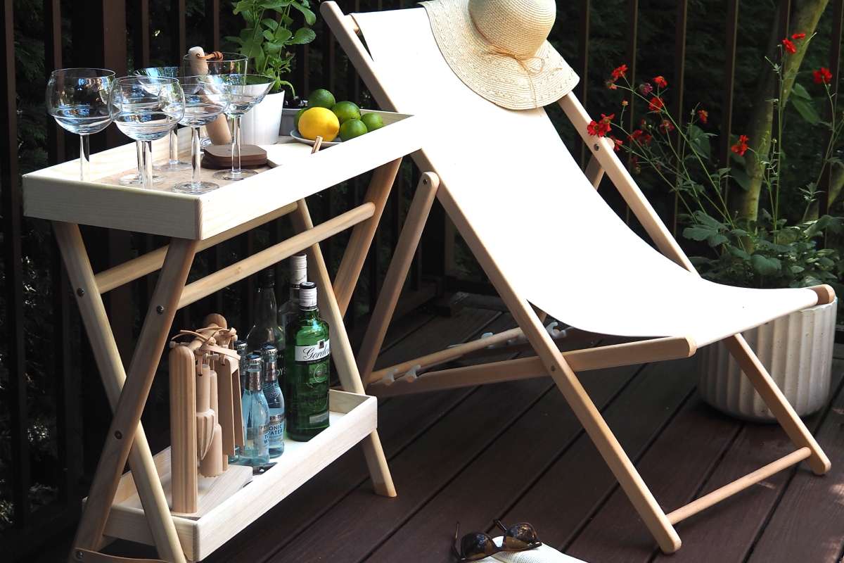 Deck chair next to a small table with glasses on a deck