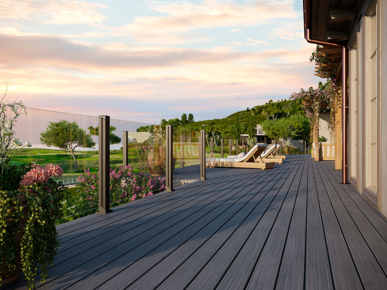 Trex frameless glass rail on a composite Trex deck overlooking a beautiful lawn at sunset.