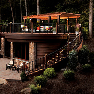 Trex Signature railing in Charcoal Black complements the vastness of a Transcend deck in Lava Rock and Tiki torch as shown in the Shenandoah Collection